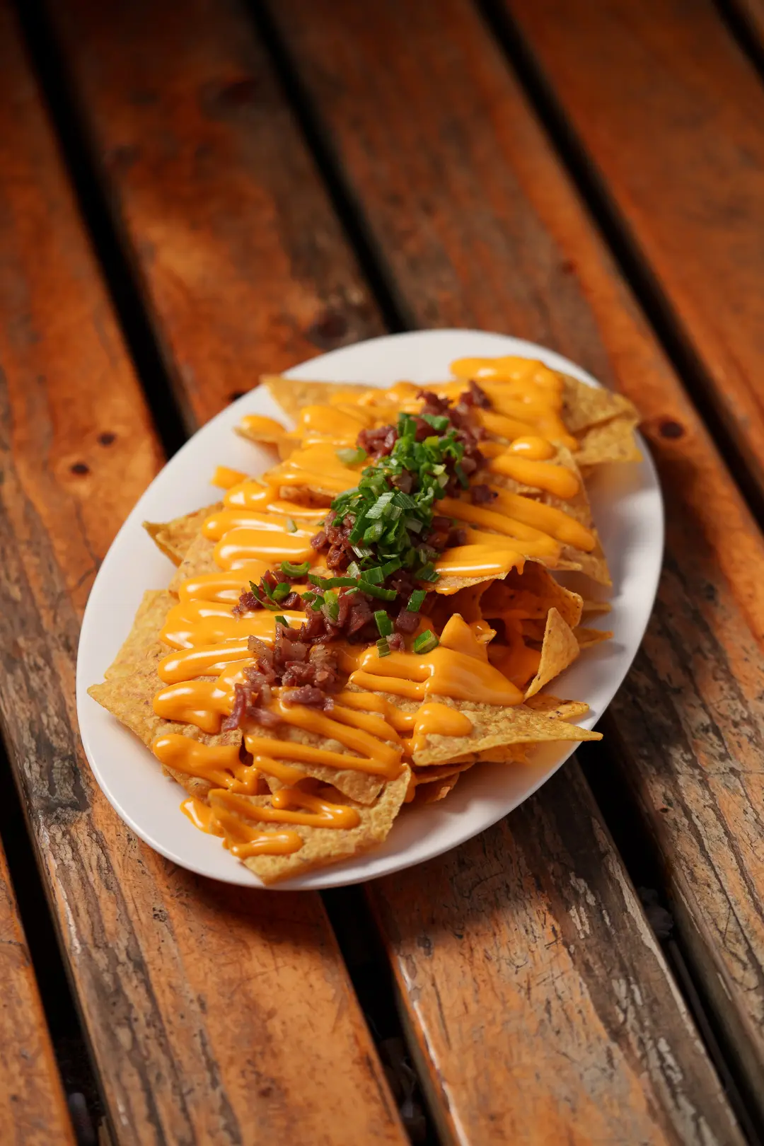 Nachos con cheddar, tocino y cebollín